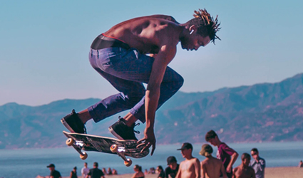 shirtless skateboarder jumping on board