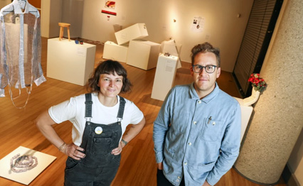 San Diego State University professors Kerianne Quick (left) and Adam John Manley are shown in the City Gallery at San Diego City College with pieces from the new exhibition “Small Acts: The Craft of Subversion.” Quick and Manley curated the exhibition, which features works that could be shipped in a U.S. Postal Service Priority Flat Rate mailer. The exhibition is on display through April 13.(Eduardo Contreras/The San Diego Union-Tribune)