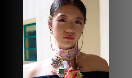 Hanna Foo, a jewelry and metalwork major, wears a necklace she made from a red packet, jewels, white lace, bracelets, crown charm, tamagotchi, CD and various costume scraps. (Photo Courtesy of Georgina Treviño)
