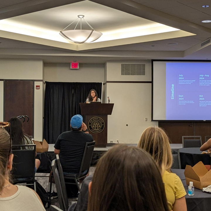 Aguilera addresses students in the Alumni Center Ballroom.