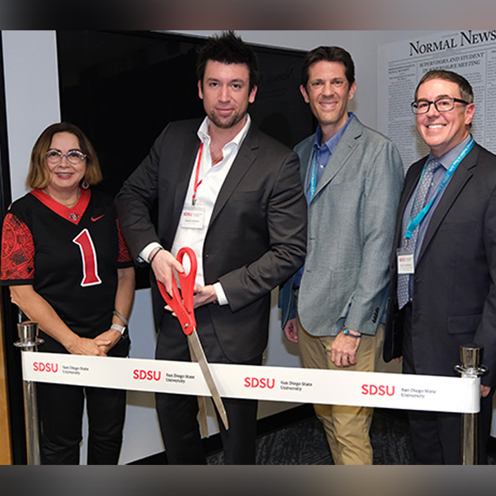 SDSU representatives cut a ribbon to celebrate the opening of a revamped newsroom space.